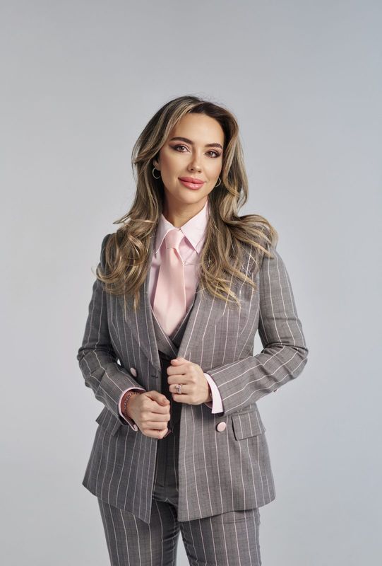 Claudia Militello în costum gri, cu cămașă roz