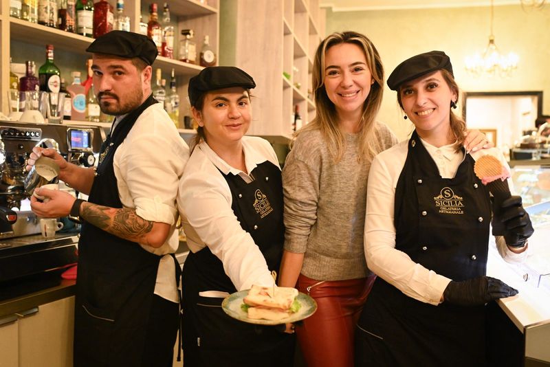 Doi bucătari prezentând preparate la bar